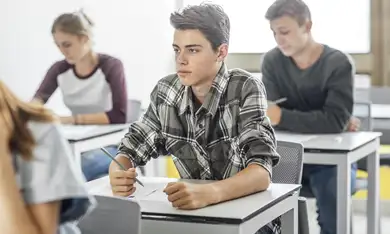 Ragazzo dai capelli corti con felpa viola con cappuccio entra in una sede Grandi Scuole