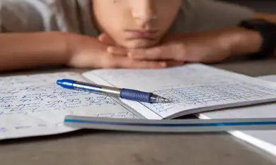 Ragazzo segue la lezione appoggiando il mento sulle mani